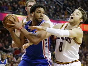 Philadelphia 76ers’ Jahlil Okafor, left, tries to get past Cleveland Cavaliers' Matthew Dellavedova in the second half of an NBA basketball game Sunday, Dec. 20, 2015, in Cleveland. The Cavaliers won 108-86. (AP Photo/Tony Dejak)