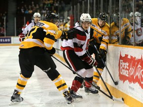 Ottawa 67's forward Ben Fanjoy tries to get out from between Kingston Frontenacs defenceman Stephen Desrocher, left, and another Frontenacs player during Ontario Hockey League action at TD Place in Ottawa on Saturday. (Chris Hofley/Postmedia Network)