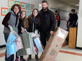 The McCreary family, from left, Christy, Fiona, Maeve and Mark, collect gifts and food at Hands for Hope on Saturday. The McCrearys then drove north to drop off their packages to a family near Perth. (Steph Crosier/The Whig-Standard)