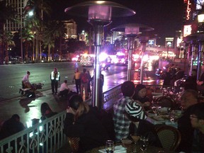 People crowd on a sidewalk while police cars and ambulances gather on a street after a car drove onto a busy sidewalk and mowed down people outside a casino in Las Vegas, Sunday, Dec. 20, 2015. (Justin Cochrane via AP)