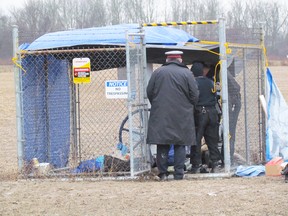 Police officers approach an Enbridge pipeline remote valve site after three protesters were taken into police custody on Monday December 21, 2015 in Sarnia, Ont. The protesters had chained themselves to the valve site. Paul Morden/Sarnia Observer/Postmedia Network