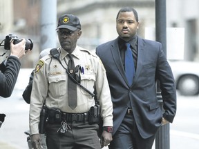 Officer William Porter, right, one of six Baltimore city police officers charged in connection to the death of Freddie Gray, arrives at a courthouse on Wednesday, Dec. 16, 2015, in Baltimore Md. A new trial for Porter has been set for June. (AP Photo/Jose Luis Magana)