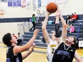 Wyatt Nicholson (7) of the MDHS senior boys basketball team battles for a rebound during recent tournament action at MDHS. Also pictured is David Dixon (left). ANDY BADER/MITCHELL ADVOCATE