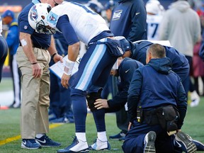 Tennessee Titans quarterback Marcus Mariota (8) has a knee brace put on during the first half against the New England Patriots at Gillette Stadium. Winslow Townson-USA TODAY Sports
