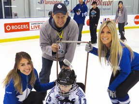 Trayton Hoskin and friend John Jordan were all grins when they posed for a picture with the Toronto Maple Leafs cheerleaders during the Easter Seals Skate for Kids event at the Mastercard Centre in Toronto Dec. 12. SUBMITTED