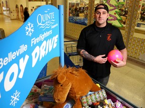 Luke Hendry/The Intelligencer
Firefighter and toy drive chairman Ryan Turcotte stands next to the donation bin in the Quinte Mall in Belleville Monday. The Belleville Professional Firefighters Christmas Toy Drive has fared well this year, he said, but needs a last-minute surge to wrap up this year and to be ready for next year.