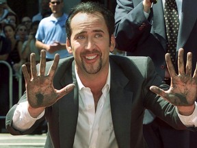 Actor Nicolas Cage smiles after placing his handprints in the forecourt at Grauman's Chinese Theater in Hollywood in this file photo taken August 14, 2001. Cage has agreed to forfeit a rare stolen dinosaur skull he bought for $276,000 to U.S. authorities so it can be returned to the Mongolian government.  REUTERS/Fred Prouser/Files
