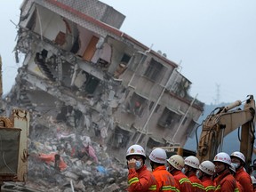 Rescuers search for potential survivors near damaged buildings following a landslide at an industrial park in Shenzhen, in south China's Guangdong province, Tuesday, Dec. 22, 2015. (AP Photo/Andy Wong)