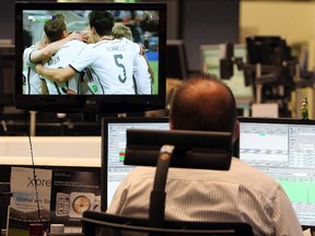Brokers are seen at work while watching a replay of the FIFA 2014 World Cup football match between Germany and Argentina at the stock exchange in Frankfurt on July 14, 2014. (AFP PHOTO/DANIEL ROLAND)