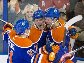 Edmonton Oilers' Andrew Ference (21), Connor McDavid (97) and Benoit Pouliot (67) celebrate a goal by McDavid against the Detroit Red Wings during second period NHL action in Edmonton, Alta., on Wednesday October 21, 2015. THE CANADIAN PRESS/Jason Franson