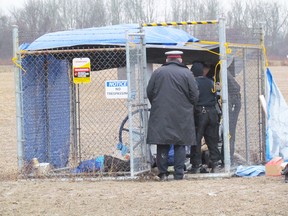 Police officers approach an Enbridge pipeline remote valve site after three protesters were taken into police custody on Monday December 21, 2015 in Sarnia, Ont. The protesters had chained themselves to the valve site. (Paul Morden, The Observer)