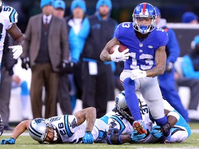 Giants wide receiver Odell Beckham Jr. (13) runs the ball past Panthers cornerback Cortland Finnegan (26) and defensive back Charles Tillman (31) during fourth quarter NFL action in East Rutherford, N.J., on Sunday, Dec. 20, 2015. (Brad Penner/USA TODAY Sports)