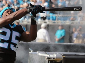 In this photo taken Dec. 13, 2015, Panthers defender Bene Benwikere swings a bat as he takes the field to play the Falcons in Charlotte, N.C. (Curtis Compton/Atlanta Journal-Constitution via AP)