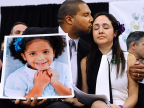 Jimmy Greene, left, kisses his wife Nelba Marquez-Greene as he holds a portrait of their daughter, Sandy Hook School shooting victim Ana Marquez-Greene. (AP Photo/Jessica Hill)