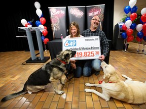 Christian Etienne and Monique Etienne (from Airdrie Alberta) take part in a press conference after winning$14,519,825 in the December 12 Lotto 6/49 draw, in St. Albert Alta. on Tuesday Dec. 22, 2015. The couples dogs Kira (left) and Chancey are also pictured. David Bloom/Edmonton Sun