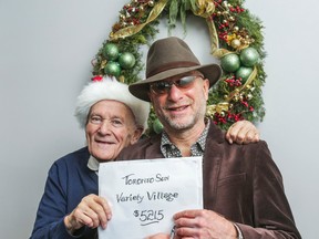 Mort Greenberg (left) poses for a photo with Toronto Sun columnist Mike Strobel with his donation to Strobel's Christmas Fund for Variety Village at the Toronto Sun. (Ernest Doroszuk/Toronto Sun)