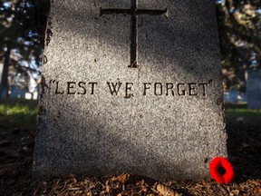 A grave stone is seen with a poppy during No Stone Left Alone at Beechmount Cemetary in Edmonton, Alta., on Tuesday, November 10, 2015. School children from across Canada lay poppies on veterans graves ahead of Remembrance Day during the event. Ian Kucerak/Edmonton Sun/Postmedia Network