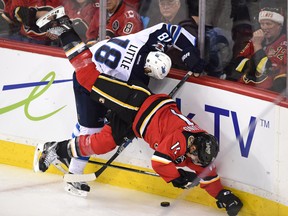 Calgary Flames centre Mikael Backlund (11) is checked by Winnipeg Jets centre Bryan Little (18).