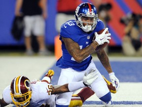 In this Sept. 24, 2015, file photo, New York Giants wide receiver Odell Beckham Jr. celebrates as Washington Redskins' Bashaud Breeland reaches for him after Beckham scored a touchdown during the second half an NFL football game in East Rutherford, N.J. (AP Photo/Bill Kostroun, File)