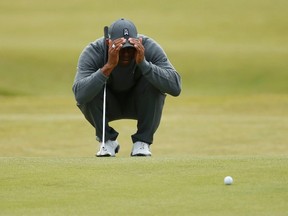 Tiger Woods lines up a putt on the seventh green during the first round of the British Open on the Old Course in St. Andrews, Scotland, on July 16, 2015. Woods hopes for a pain-free 2016 and a return to championship-level play. (Lee Smith/Reuters)