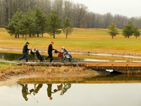 Golfers make their way across a footbridge on the first fairway during above seasonal 10C weather on Wednesday December 23, 2015 at Keystone Links Golf and Country Club on Clifford Line in Peterborough, Ont. Environment Canada is forecasting a high of 14C for Christmas Eve. Clifford Skarstedt/Peterborough Examiner/Postmedia Network