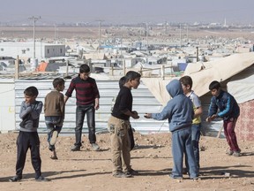 Young Syrian refugees play in the Zaatari Refugee Camp, near the city of Mafraq, Jordan, on Nov. 29, 2015. For years, the millions displaced by the ongoing civil war in Syria hardly registered on Canada's radar, but a single death this fall suddenly brought the conflict home. 
THE CANADIAN PRESS/Paul Chiasson
