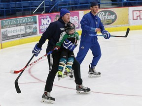 Dmitry Sokolov, left, of the Sudbury Wolves, goofs around with Charlie Matsos, 5, son of Wolves head coach Dave Matsos, as injured Wolves player David Levin looks on during a free skate at the Sudbury Community Arena in Sudbury, Ont. on Wednesday December 23, 2015.