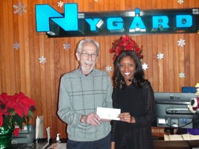 Nikeisha Paul, Nygard's special events assistant, presents a cheque to Kai Madsen, executive director of the Christmas Cheer Board.