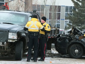 Edmonton Police Service members investigate the scene where an EPS SUV crashed into a fleeing stolen Ford 350 truck on Roper Roper and 62 St., in Edmonton on Monday Dec. 21, 2015. Their were no injuries and one man is in custody and charges are pending. Tom Braid/Edmonton Sun