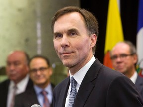 Finance Minister Bill Morneau holds a news conference as his provincial and territorial counterparts look on after concluding a meeeting in Ottawa Monday, December21, 2015. THE CANADIAN PRESS/Fred Chartrand