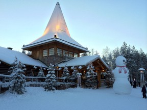 A child looks at a large snowman in Santa Claus Village, around 8 kms, 5 miles north of Rovaniemi in Finland on Tuesday Dec. 15, 2015. Most kids learn that Santa Claus comes from the North Pole, but children in Scandinavia are taught he lives a bit further south. Where exactly is a matter of much debate, with businesses in Finland, Sweden and Norway competing to cash in on the cache that comes with claiming Santa’s hometown. (AP Photo/James Brooks)