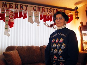 Irene Genest, 78, stands in front of 41 Christmas stockings she made for each member of her family, including seven children, 16 grandchildren and eight great grandchildren, at her central Edmonton,  home on Wednesday, December 23, 2015. (TREVOR ROBB/Edmonton Sun)