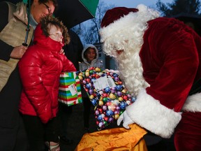 In this Dec. 17, 2015, file photo, Safyre Terry receives packages from Santa Claus in Rotterdam, N.Y. Terry, who lost her father and siblings in an arson fire that left her severely scarred is sharing the good cheer bestowed on her by the truckload since her simple Christmas wish went viral. (AP Photo/Mike Groll, File)