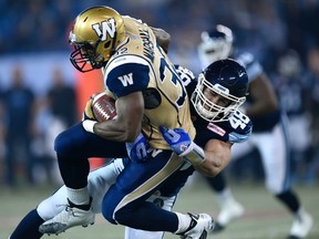 Toronto Argonauts' Thomas Miles takes down Winnipeg Blue Bombers' Cameron Marshall. (THE CANADIAN PRESS/Frank Gunn