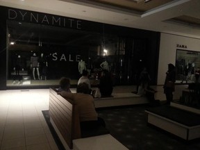 Shoppers sit in semi-darkness inside the Bayshore Shopping Centre during a power outage on Thursday morning -- as hordes of last-minute shoppers were trying to squeeze in their final pre-Christmas purchases. (JULIENNE BAY Ottawa Sun / Postmedia Network)