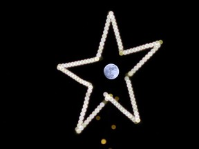 The Full Cold Moon seen through the star of a Christmas tree in Beirut, Lebanon, Thursday, Dec. 24, 2015. The full moon, which is the last of the year, is called the Full Cold Moon because it occurs at the start of winter. The last time there was a full moon on 25 December was 1977, and there won't be another one until 2034. (AP Photo/Hassan Ammar)