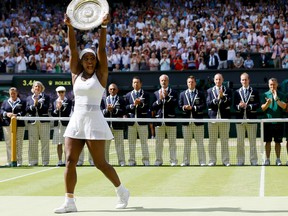 Serena Williams holds up the trophy after winning the Wimbledon final against Garbine Muguruza at the All England Lawn Tennis Championships in London on July 11, 2015. For the fourth time, Williams has been named The Associated Press Female Athlete of the Year. (Kirsty Wigglesworth/AP Photo)
