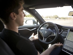 New autopilot features are demonstrated in a Tesla Model S during a Tesla event in Palo Alto, Calif.