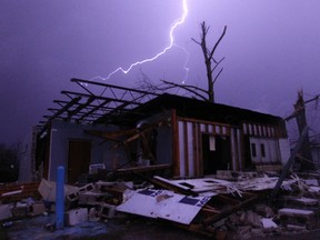 Lightning illuminates a house after a tornado touched down in Jefferson County, Ala., damaging several houses, Friday, Dec. 25, 2015, in Birmingham, Ala.  (AP Photo/Butch Dill)