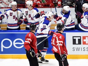 Canada's Brandon Hickey (6) and Haydn Fleury (4) look on as the United States' Colin White (18) celebrates his goal with teammates during second period preliminary hockey action at the IIHF World Junior Championship in Helsinki, Finland on Saturday, Dec. 26, 2015. (Sean Kilpatrick/THE CANADIAN PRESS)