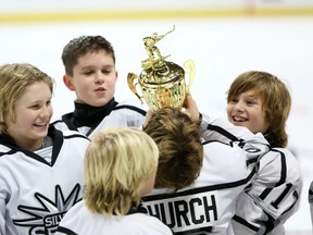 Ottawa Valley Silver Seven's Ben Church kisses the trophy after his Major Atom AA team won the Bell Capital Cup championship during the 2014-15 tourney. (Chris Hofley/Ottawa Sun)​