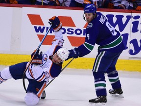 Dec 26, 2015; Vancouver, British Columbia, CAN; Edmonton Oilers forward Matt Hendricks (23) goes down in front of Vancouver Canucks forward Brandon Prust (9) during the third period at Rogers Arena. The Vancouver Canucks won 2-1 in overtime. Mandatory Credit: Anne-Marie Sorvin-USA TODAY Sports