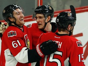 Ottawa Senators' Mark Stone (61) celebrates his goal with teammates Kyle Turris (7) and Zack Smith (15) during first period NHL hockey action against the Boston Bruins in Ottawa on Sunday, December 27, 2015. THE CANADIAN PRESS/Fred Chartrand
