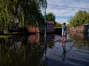 A youth balances on a woods crate outside his flooded home in Concordia, Argentina on Monday, Dec. 28, 2015. At least 20,000 have been evacuated in Argentina. Neighboring Paraguay has been hardest hit, with 100,000 evacuating. Several thousand have also been evacuated in Uruguay and southern Brazil. (AP Photo/Natacha Pisarenko)