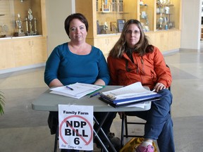 Corrine Erickson (left) and another volunteer were seen at an event at Frank Maddock High School recently where people were signing Bill 6 and carbon tax plebiscites.