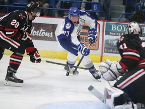 Sudbury Wolves Matt Schmalz tries to control the puck in front of Niagara Ice Dogs goalie Brent Moran, as Dogs defence man Aaron Haydon comes in on the play at the Sudbury Community Arena in Sudbury, Ont. on Friday September 25, 2015.