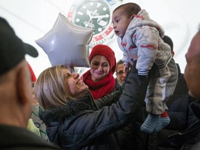 Tima Kurdi, left, who lives in the Vancouver area, lifts up her 5-month-old nephew Sherwan Kurdi after her brother Mohammad Kurdi and his family, who escaped the war in Syria, arrived at Vancouver International Airport, in Richmond, B.C., on Monday, Dec. 28, 2015. Tima Kurdi's other brother Abdullah, whose young sons and wife died when their boat capsized during a desperate voyage from Turkey to Greece, abandoned his attempt to emigrate. Looking on at centre is Haveen Kurdi, 16, Mohammad's eldest daughter. THE CANADIAN PRESS/Darryl Dyck