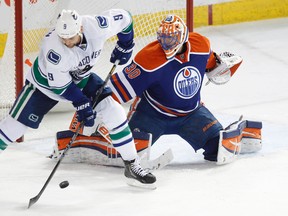 Edmonton goaltender Ben Scrivens (30) and Vancouver forward Zack Kassian (9) are seen during the third period of an NHL game between the Edmonton Oilers and the Vancouver Canucks at Rexall Place in Edmonton, Alta., on Saturday, April 12, 2013. The Oilers won 5-2. Ian Kucerak/Edmonton Sun