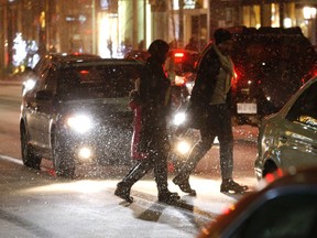 People cross Bloor St during this winter's first snowfall. (MICHAEL PEAKE, Toronto Sun)