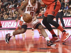 Chicago Bulls guard Aaron Brooks (0) dribbles the ball as Toronto Raptors center Jonas Valanciunas (17) defends during the first half at  the United Center on Dec. 28, 2015. (DAVID BANKS/USA TODAY Sports)